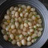 Cooked Caballero beans, sprinkled with black pepper, basil to garnish.