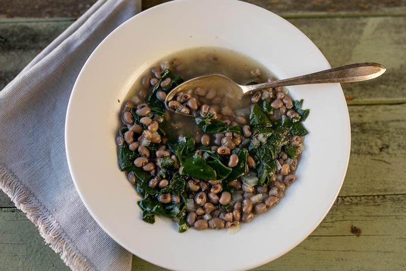 White bowl with cooked Blue Goose Field Peas topped with kale - Rancho Gordo 
