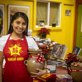 Rancho Gordo female employee wearing a Red Apron holding a clay bean pot 