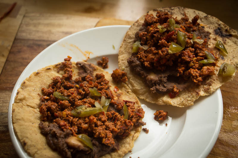 Two tacos with refried beans and chorizo topped with cut jalapeños - Rancho Gordo, Heirloom beans