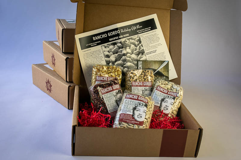 Holiday 2023 Gift Box- two bags of Cassoulet beans, One bag of White Corn Posole, One bag of Black Eyed Peas, One bag of Crimson Popping corn. With a flyer with recipes. 