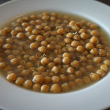 A white bowl of ceci piccoli-- plain with a drizzle of olive oil