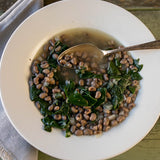 White bowl with cooked Blue Goose Field Peas topped with kale - Rancho Gordo 