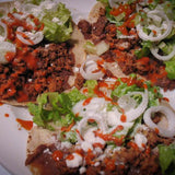 Three tacos with refried Pinto beans topped with onion, lettuce, and feta - Rancho Gordo, Heirloom beans