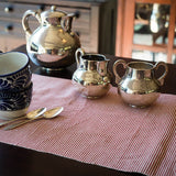 Natural Dye Table Runner display in a table with a silver tea set and cups with spoon. 