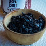In a brown bowl there's the Black Urfa Chili with the bottle behind