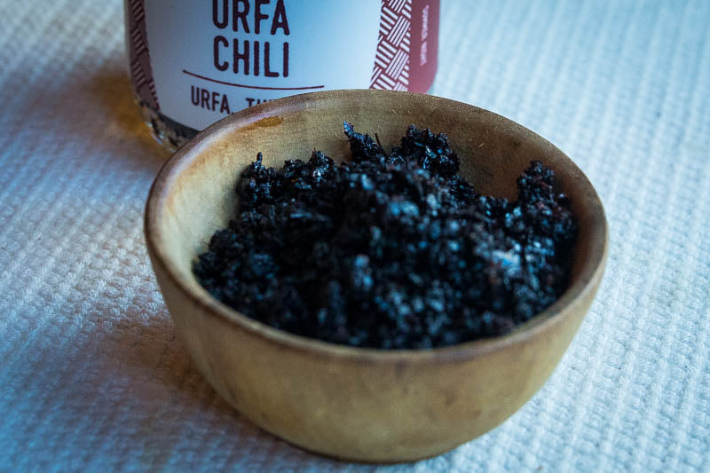 In a brown bowl there's the Black Urfa Chili with the bottle behind
