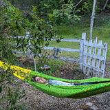 Handwoven Hammock with a boy laying down surround by trees 