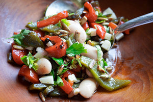 White beans, red and green peppers and parsely salad in a wooden bowl