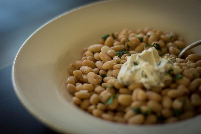 Cooked Alubia Blanca, topped with ricotta cheese and herbs-Rancho Gordo, Heirloom beans.