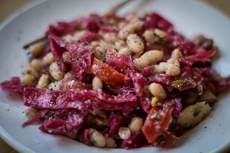 Cooked Alubia Blanca mixed with sautéed red cabbage and tomatoes, sprinkled with black pepper-Rancho Gordo, Heirloom beans.