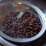 Rancho Gordo- cooked black garbanzo in a strainer under a bowl. 